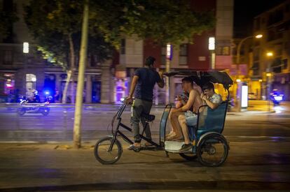 Unos turistas regresan a casa con un 'rickshaw' después del toque de queda en Barcelona. En total, la medida afecta a más del 80% de los ciudadanos de Cataluña, es decir, a unos seis millones de personas.