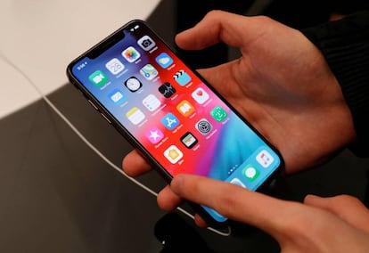 FILE PHOTO: A customer tests a smartphone during the launch of the new iPhone XS and XS Max sales at a shop in Moscow