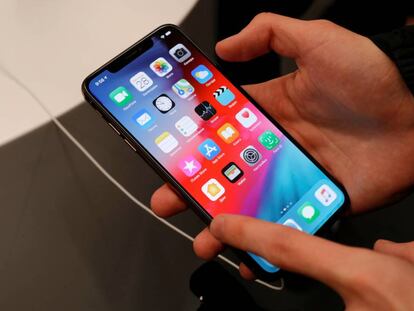 FILE PHOTO: A customer tests a smartphone during the launch of the new iPhone XS and XS Max sales at a shop in Moscow