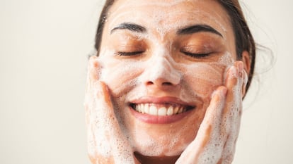 Chica lavándose la cara en su rutina de cuidado facial