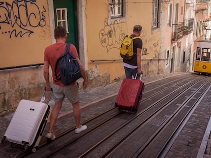 Dos jóvenes caminan por la rua da Bica de Duarte Belo de Lisboa (Portugal).