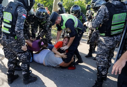 Mujeres familiares de reos de la prisión de Tacumbú son sometidas por la policía, afuera del penal, en Asunción (Paraguay), este lunes.