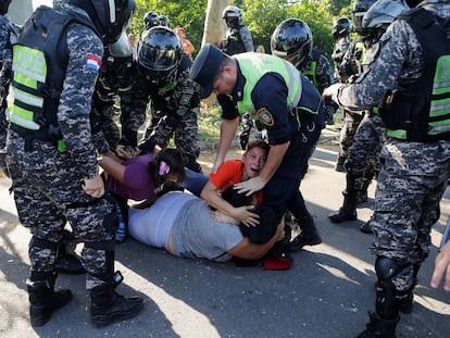 Mujeres familiares de reos de la prisión de Tacumbú son sometidas por la policía, afuera del penal, en Asunción (Paraguay), este lunes.