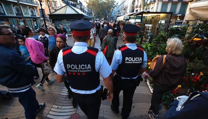 A pair of Catalan regional police officers walk down La Rambla in Barcelona.