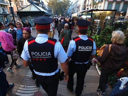 A pair of Catalan regional police officers walk down La Rambla in Barcelona.