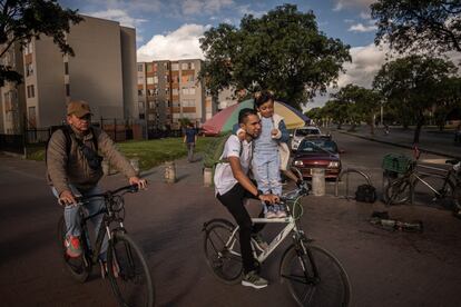 Un ciclista transporta a una niña  en la ciclorruta de Alameda Porvenir, que conecta al municipio vecino de Soacha con las localidades de Fontibón, Kennedy y Bosa en el sur occidente de Bogotá.