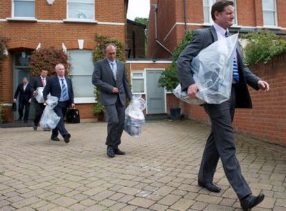 Agentes de Scotland Yard salen con bolsas con pruebas tras un registro en la casa de Andy Coulson, exjefe de Comunicación del primer ministro, en Londres.