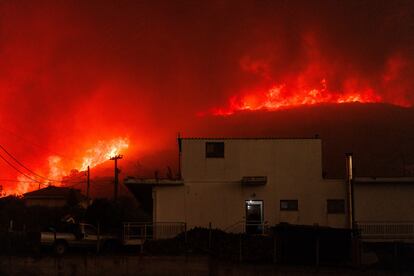 Un incendio forestal quema un bosque cerca de una casa en el pueblo de Avantas (Grecia), el lunes.
