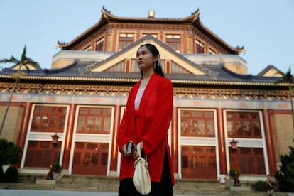 Una mujer vestida con ropas tradicionales se para frente al Sun Yat-sen Memorial hall en el distrito de Xinji en Guanghzou (China).
