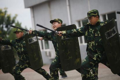 Varios niños reciben entrenamiento durante el campamento militar.