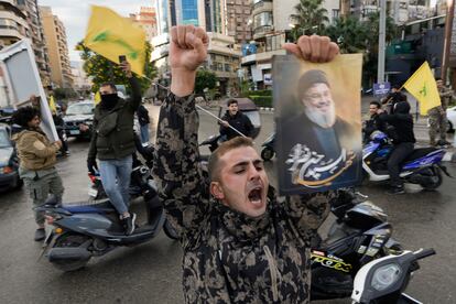 Un hombre sujeta una fotografía del líder asesinado de Hezbolá, Hassan Nasrallah, mientras celebra el acuerdo alcanzado de alto al fuego en Dahiyeh, Beirut. 