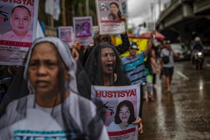 Familiares de presuntos muertos extrajudiciales usan velos mientras participan en una protesta contra los asesinatos de la guerra contra las drogas afuera de la sede militar y policial el 17 de julio de 2019 en Manila (Filipinas).