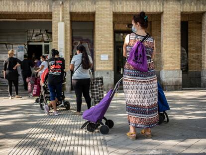 Un grupo de personas espera su turno en un banco de alimentos en el barrio de Orcasitas, Madrid, en marzo de 2021.