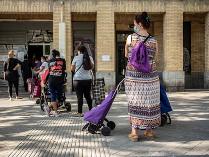 Un grupo de mujeres espera su turno en un local del Banco de Alimentos en el barrio de Orcasitas, Madrid.