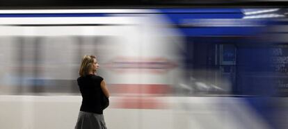 Una viajera en un andén, ante un vagón de metro. 