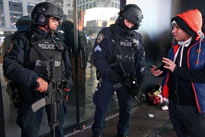Un peatón pide instrucciones de dos oficiales de contraterrorismo fuertemente armados estacionados en Times Square, Nueva York (EE.UU).