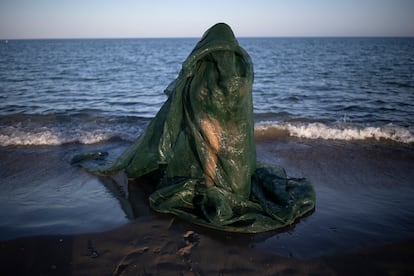 Alessandra García in green swimsuit and networks surrounding her body, on Guadalmar beach, during one of her trials.