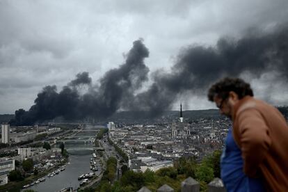 Un hombre observa el humo que se eleva desde una fábrica en llamas de Lubrizol en el noroeste de Francia. 