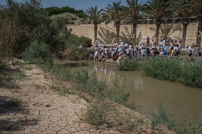 Un grupo de peregrinos se prepara para su bautizo en la parte oriental del río, en Cisjordania, mientras que la orilla opuesta se ve completamente seca. Durante los últimos años, este emplazamiento histórico ha visto como el cauce ha bajado drásticamente hasta llegar a niveles preocupantes. “El caudal del Jordán se ha reducido un 96% desde el inicio de los registros: ha pasado de 1.300 millones de metros cúbicos por año a unos 50 y 120 millones de metros cúbicos según la temporada", explica Ibrahim Alkilani, coordinador de proyectos de la ONG EcoPeace Middle East.
