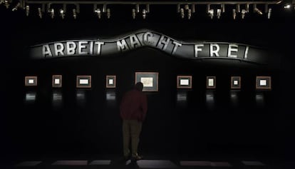 Una sala de la exposición, con el cartel de la entrada del campo de Auschwitz, en el que se lee "El trabajo os hará libres"