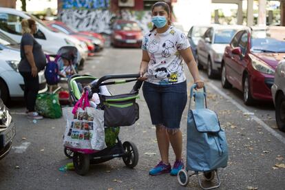 Carol from Brazil waits in line with her daughter to collect food donations.