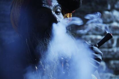 Un santo hindú fuma marihuana en el patio del tempo Pashupatinath, la víspera del festival Shivaratri en Katmandú (Nepal). 
