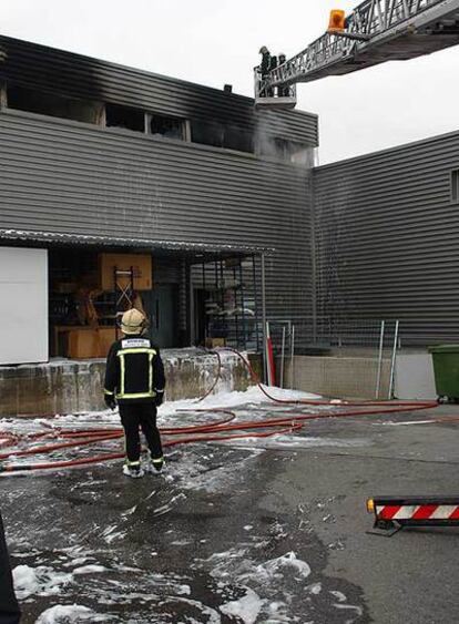 Los bomberos trabajan en la nave de recambios de automóvil que ha ardido esta mañana en la localidad madrileña.