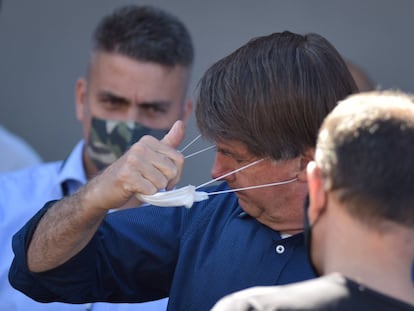 El presidente de Brasil, Jair Bolsonaro, se quita el tapabocas este sábado.