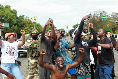 Varias personas posan con soldados al origen del golpe de Estado, en una calle de Libreville, Gabón el pasado 20 de agosto.