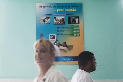 Una enfermera ante un cartel en la que el Ministerio de Salud Cubano advierte de los costes de cada gestión médica con el fin de sensibilizar a la población del gasto sanitario.