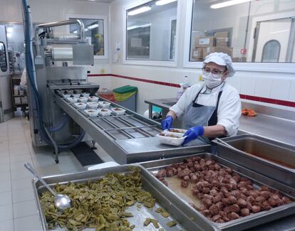 Una mujer prepara comida en un servicio de cátering.