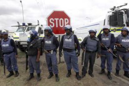 Policías sudafricanos bloquean una carretera para evitar que los manifestantes lleguen a la comisaría en Rustenburg (Sudáfrica). EFE/Archivo