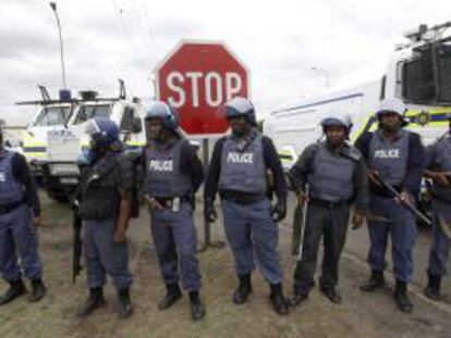 Policías sudafricanos bloquean una carretera para evitar que los manifestantes lleguen a la comisaría en Rustenburg (Sudáfrica). EFE/Archivo