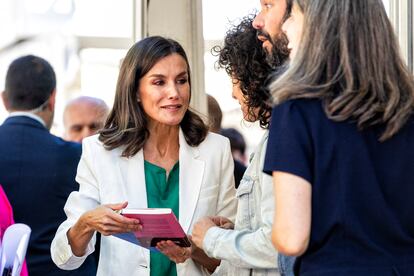 La reina Letizia aprecia varios libros en una de las casetas.