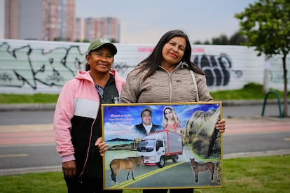 María Cantor y Sandra Milena Cantor sostienen el cuadro de recuerdo de sus caballos, en Bogotá, el 8 de marzo de 2024. 