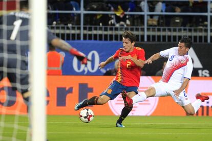 Álvaro Odriozola golpea el balón presionado por el costarricense Bryan Oviedo.