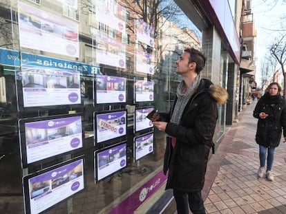 Un joven mira el escaparate de una inmobiliaria en Madrid. 