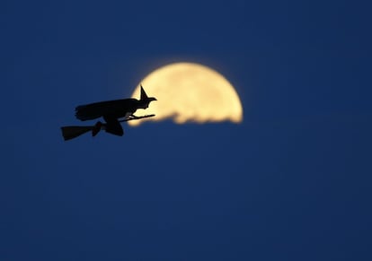 Un aparato de radio control, con forma de bruja, vuela junto a la luna en California (EE UU), el 8 de octubre de 2014.