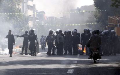 Policías intentan controlar los disturbios durante una manifestación de ciudadanos iraníes en Teherán.