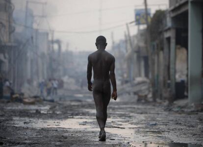 Um homem nu caminha pelas ruas destruídas de Porto Príncipe após o grande terremoto de 12 de janeiro de 2010.