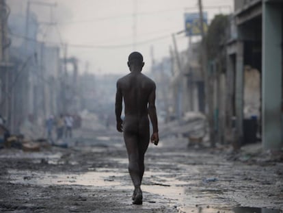 Um homem nu caminha pelas ruas destruídas de Porto Príncipe após o grande terremoto de 12 de janeiro de 2010.