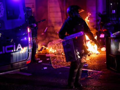 Un policía se abre paso entre los furgones y el fuego provocado por los ultras.