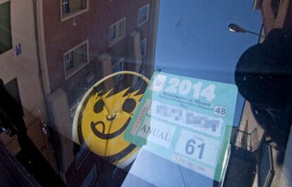 Un vehículo estacionado con la tarjeta verde para residentes.