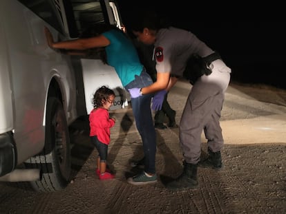 Menina hondurenha chora enquanto sua mãe é revistada pela patrulha fronteiriça em McAllen (Texas), em 2018.