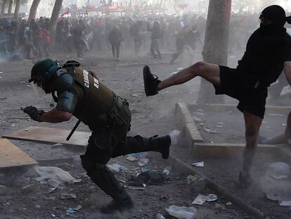 Manifestantes e policiais se enfrentam durante a manifestação em Santiago, nesta terça-feira.