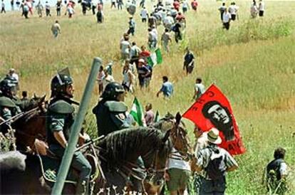 Guardias civiles a caballo dispersan a los jornaleros que ayer participaron en el corte de la N-IV.