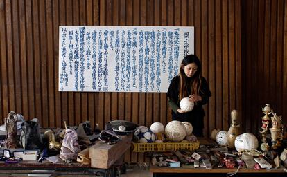 Una mujer busca pertenencias familiares entre los objetos recuperados de las ruinas.