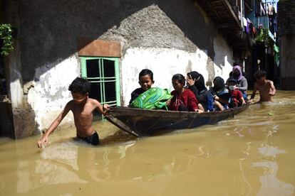 Una familia es evacuada de su casa inundada tras las fuertes lluvias en Bandung, Indonesia.