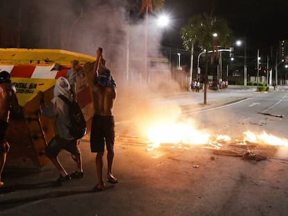 Un grupo de hombres empuja un contenedor para hacer una barricada en la ciudad brasileña de Vitória.