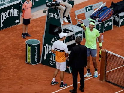 Nishikori y Nadal hablan con el supervisor antes de la suspensión, este martes en París.